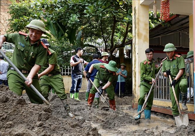 Lực lượng công an huyện Mù Cang Chải dọn dẹp bùn đất tại trường Phổ Thông dân tộc bán trú TH và THCS xã Hồ Bốn. Ảnh: Tuấn Anh - TTXVN