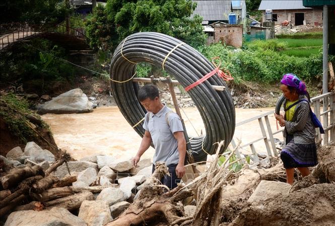 Một hộ dân ở bản Đề Sủa, xã Lao Chải mua ống nước về khắc phục nguồn nước sạch bị hư hỏng do mưa lũ. Ảnh: Tuấn Anh - TTXVN