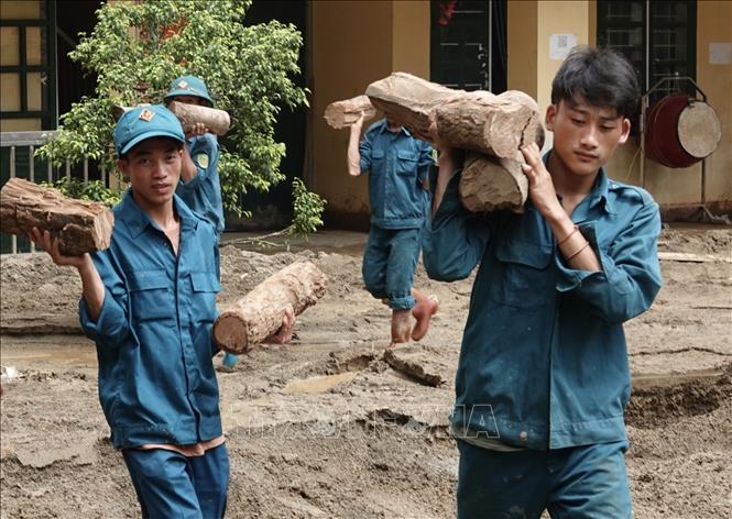 Lực lượng dân quân tham gia khắc phục bão lũ tại trường Phổ Thông dân tộc bán trú TH và THCS xã Hồ Bốn. Ảnh: Tuấn Anh - TTXVN