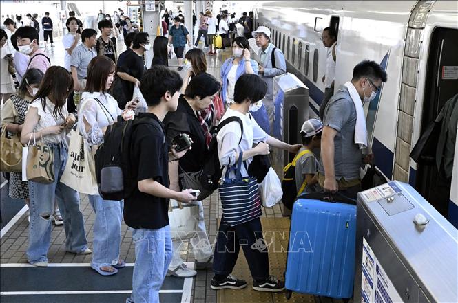 Người dân lên tàu  trở về quê nhà đón lễ Obon tại nhà ga ở Osaka, Nhật Bản, ngày 13/8/2023. Ảnh: Kyodo/TTXVN
