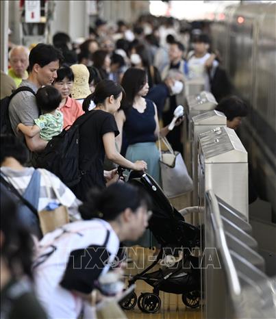 Người dân lên tàu  trở về quê nhà đón lễ Obon tại nhà ga ở Osaka, Nhật Bản, ngày 13/8/2023. Ảnh: Kyodo/TTXVN