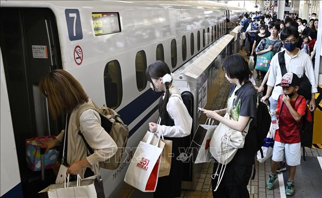 Người dân lên tàu  trở về quê nhà đón lễ Obon tại nhà ga ở Osaka, Nhật Bản, ngày 13/8/2023. Ảnh: Kyodo/TTXVN