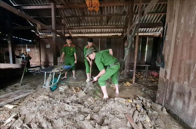 Công an huyện Than Uyên (Lai Châu) giúp dân dọn bùn đất tràn vào nhà do mưa lũ tại bản Hô Ta, xã Tà Mung. Ảnh: TTXVN phát