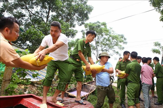 Công an huyện Chương Mỹ (Hà Nội) tham gia cứu trợ, vận chuyển lương thực để ổn định cuộc sống nhân dân trong những ngày mưa lũ cuối tháng 7/2018. Ảnh: Cương Quyết-TTXVN