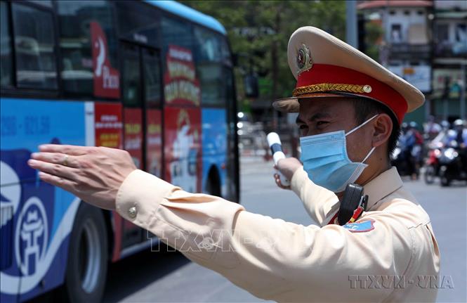 Chiến sĩ CSGT Hà Nội làm nhiệm vụ phân luồng, điều tiết giao thông tại ngã tư Đại Cồ Việt - Giải Phóng trong tình trạng nắng nóng lên tới 40 độ C. Ảnh: Phạm Kiên - TTXVN