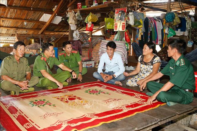 Công an chính quy và công an viên xã Ia Rvê, huyện Ea Súp, tỉnh Đắk Lắk thăm hỏi nhân dân sống ở tuyến biên giới giáp với Campuchia. Ảnh: Doãn Tấn – TTXVN