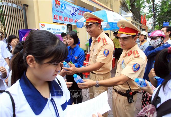 Chiến sĩ CSGT Hải Phòng động viên tinh thần các sĩ tử tham gia Kỳ thi tốt nghiệp THPT quốc gia năm 2018. Ảnh: An Đăng - TTXVN