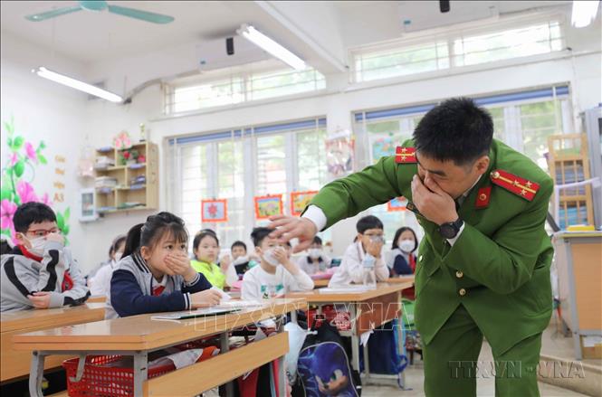 Công an quận Ba Đình (Hà Nội) hướng dẫn học sinh phòng tránh khói độc và cách di chuyển ra khỏi lớp khi có đám cháy xảy ra. Ảnh: Thanh Tùng - TTXVN