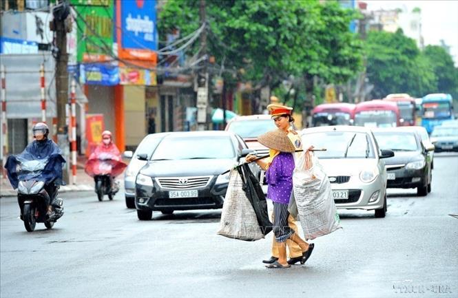 Nữ CSGT Công an thành phố Ninh Bình giúp người khuyết tật sang đường. Ảnh: Minh Đức - TTXVN