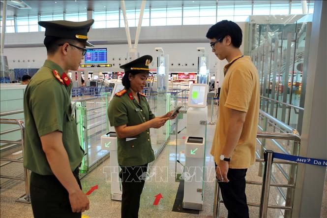 Công an cửa khẩu Cảng hàng không quốc tế Đà Nẵng hỗ trợ việc sử dụng hệ thống Cổng kiểm soát tự động xuất cảnh. Ảnh: Trần Lê Lâm - TTXVN 