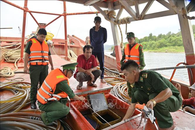 Cán bộ, chiến sĩ Biên phòng đo số lượng đầu trên tàu KG-94337-TS. Ảnh: TTXVN phát