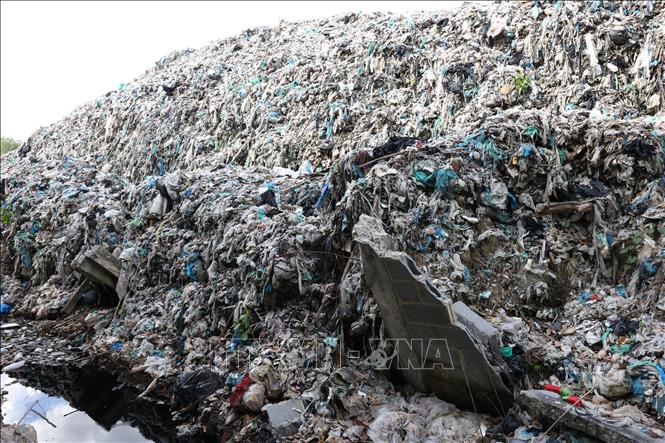 Tường rào khoảng 50m bao quanh của bãi rác của Công ty Cổ phần công nghệ môi trường Tây Ninh đỗ sập, rác tràn qua đất canh tác của người dân. Ảnh: Thanh Tân - TTXVN