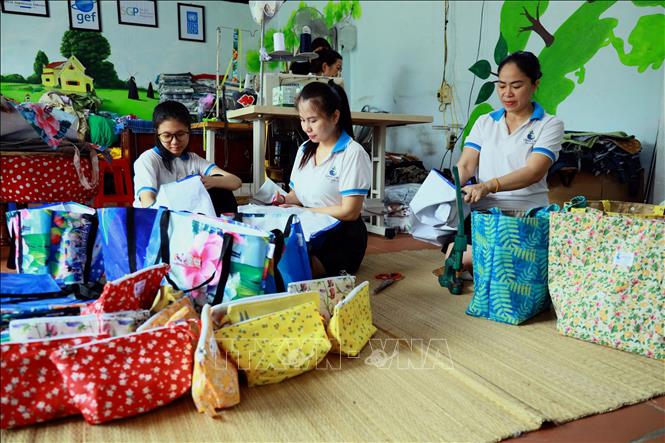 Hoàn thiện các sản phẩm túi xách làm từ bạt nhựa, pano, vải vụn. Ảnh: Đức Hiếu - TTXVN
