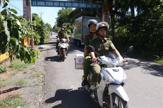 Trung tá Lê Thị Thùy Dung cùng lực lượng công an xã tuần tra bảo vệ an ninh trật tự tại địa bàn xã Đại Điền. Ảnh: Huỳnh Phúc Hậu - TTXVN