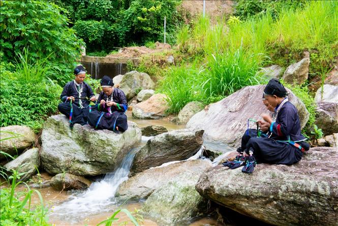 Young people use their free time to make dolls in their own traditional clothes. VNA Photo: Nam Thái
