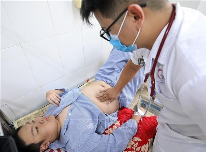 Bác sĩ Bệnh viện đa khoa Đống Đa thăm khám cho bệnh nhân mắc sốt xuất huyết. Ảnh: Minh Quyết - TTXVN
