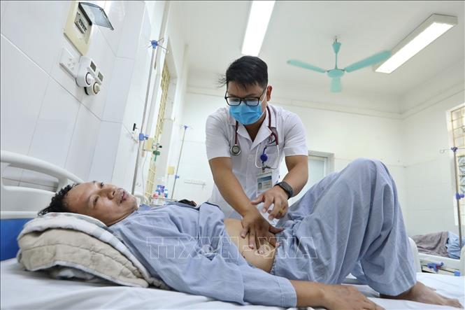 Bác sĩ Bệnh viện đa khoa Đống Đa thăm khám cho bệnh nhân mắc sốt xuất huyết. Ảnh: Minh Quyết - TTXVN