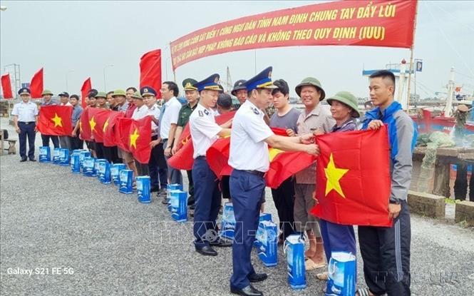Bộ Tư lệnh Vùng Cảnh sát biển 1 tặng cờ Tổ quốc cho ngư dân. Ảnh: TTXVN phát