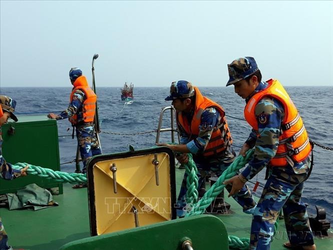 Cán bộ, chiến sĩ Hải đội 402, Bộ Tư lệnh Vùng Cảnh sát biển 4 hỗ trợ lai dắt tàu ngư dân gặp nạn vào bờ (2018). Ảnh: Huỳnh Thế Anh - TTXVN