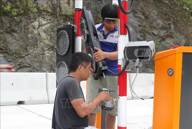Nhà thầu đang gấp rút lắp đặt thiết bị tại trạm thu phí. Ảnh: Quốc Khánh - TTXVN