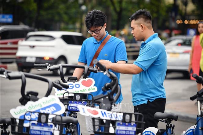 Người dân trải nghiệm dịch vụ xe đạp công cộng trong ngày đầu tiên hoạt động. Ảnh: Tuấn Anh - TTXVN