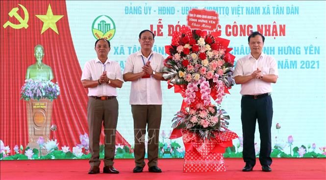 Chủ nhiệm Uỷ ban Kiểm tra Tỉnh uỷ Hưng Yên Bùi Thế Cử (bên phải) tặng hoa chúc mừng Đảng bộ, chính quyền và nhân dân xã Tân Dân, huyện Khoái Châu. Ảnh: Đinh Văn Nhiều - TTXVN