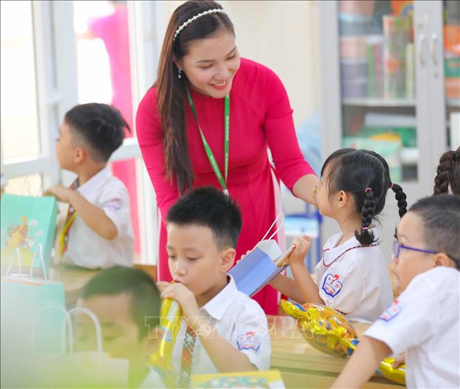 Giáo viên Trường tiểu học Thăng Long tặng quà cho học sinh trong ngày đầu vào lớp 1. Ảnh: Thanh Tùng - TTXVN