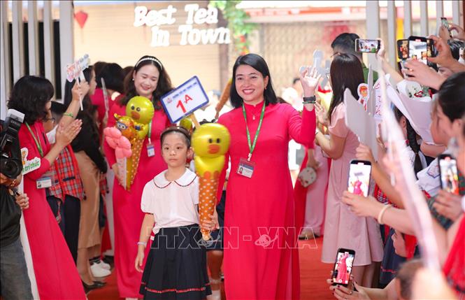 Cô giáo Nguyễn Thị Bình Minh, Hiệu trưởng Trường tiểu học Thăng Long đón học sinh lớp 1 tới trường. Ảnh: Thanh Tùng - TTXVN 