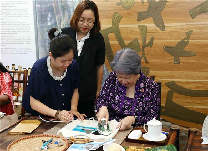 Bà Hà Tinh, Phu nhân Thủ tướng Singapore Lý Hiển Long trải nghiệm ghép tranh từ vải lụa vụn. Ảnh: Phạm Kiên - TTXVN