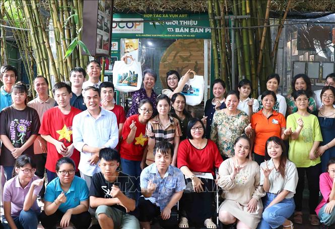 Bà Lê Thị Bích Trân, Phu nhân Thủ tướng Phạm Minh Chính và bà Hà Tinh, Phu nhân Thủ tướng Singapore Lý Hiển Long cùng các thành viên của Hợp tác xã Vụn Art. Ảnh: Phạm Kiên - TTXVN