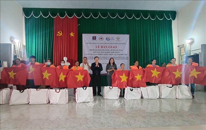 Trao áo phao và cờ Tổ quốc cho ngư dân vùng biển. Ảnh: Huỳnh Phúc Hậu - TTXVN