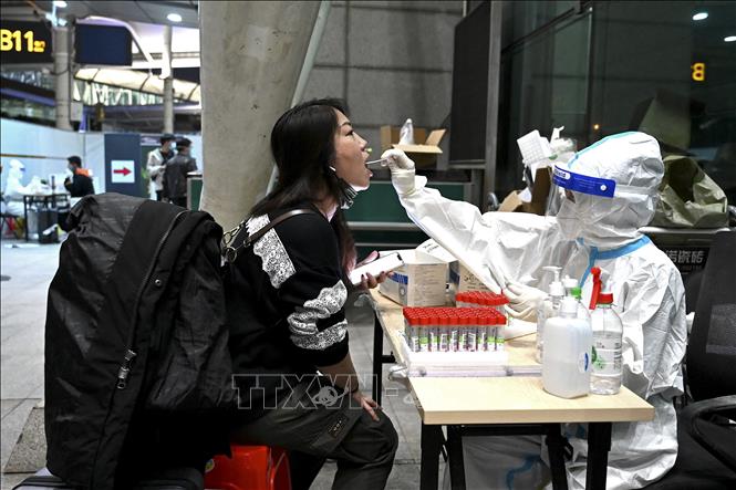 (Tư liệu) Nhân viên y tế lấy mẫu xét nghiệm COVID-19 cho hành khách tại sân bay ở Quảng Châu, Trung Quốc. Ảnh: AFP/TTXVN 