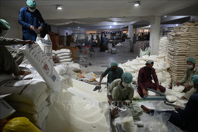 Công nhân đóng gói đường tại một nhà kho ở Islamabad, Pakistan. Ảnh: AFP/TTXVN