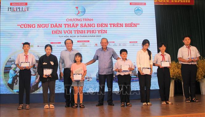 Nguyên Phó Thủ tướng Chính phủ Trương Hòa Bình cùng đại diện lãnh đạo Báo Pháp Luật Thành phố Hồ Chí Minh trao học bổng cho con em ngư dân. Ảnh: Tường Quân – TTXVN