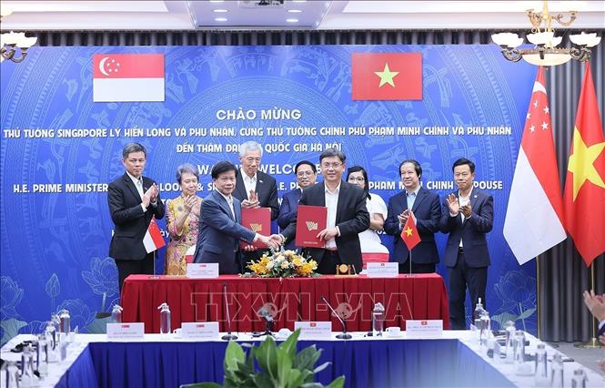 PMs Pham Minh Chinh and Lee Hsien Loong witness the signing of a cooperation agreement between VNU-Ho Chi Minh City and Nanyang Technological University (TNU) of Singapore. VNA Photo: Dương Giang