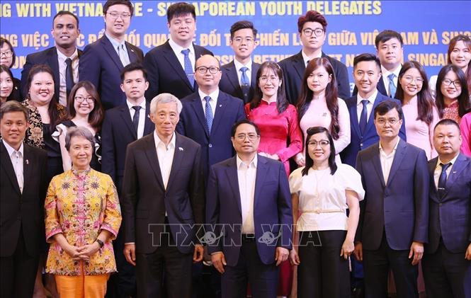 PMs Pham Minh Chinh and Lee Hsien Loong have a dialogue with young leaders of the two countries. VNA Photo: Dương Giang