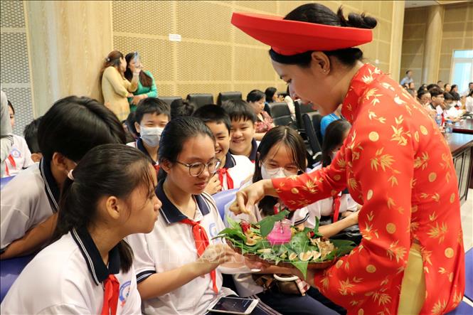 Cán bộ Bảo tàng tỉnh Bà Rịa-Vũng Tàu giới thiệu cho học sinh về trầu têm cánh phượng. Ảnh: Đoàn Mạnh Dương - TTXVN
