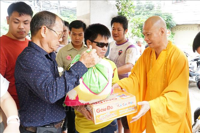 Disadvantaged Vietnamese and Lao people receive gifts at the event. VNA Photo: Đỗ Bá Thành