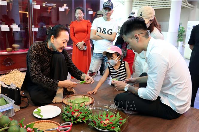 Hướng dẫn du khách cách têm trầu. Ảnh: Đoàn Mạnh Dương - TTXVN
