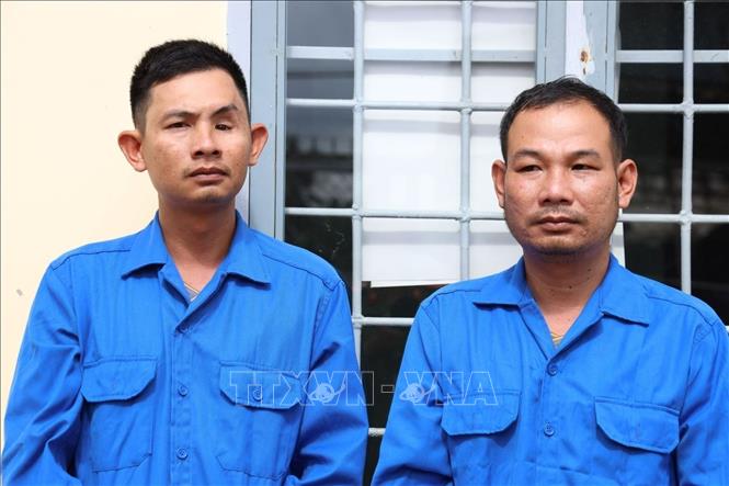 Đối tượng Vũ Minh Tân (bên phải) và Vũ Minh Long (bên trái) bị tạm giữ hình sự tại cơ quan Cảnh sát điều tra Công an huyện Tân Biên, tỉnh Tây Ninh. Ảnh: TTXVN phát