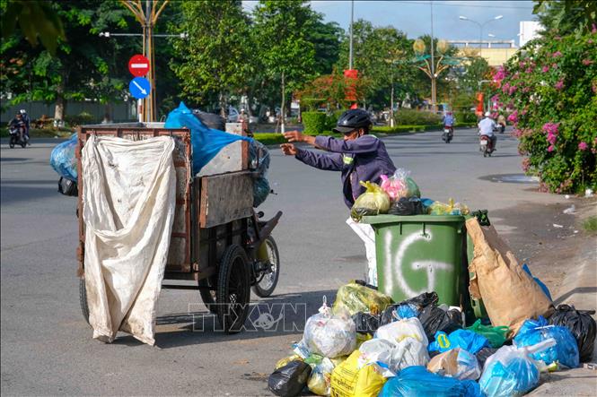 Do thiếu phương tiện nên Công ty Cổ phần Đô thị Cần Thơ phải cử công nhân dùng xe thô sơ đi lấy rác trên đường Mai Chí Thọ, quận Cái Răng. Ảnh: Thanh Liêm - TTXVN