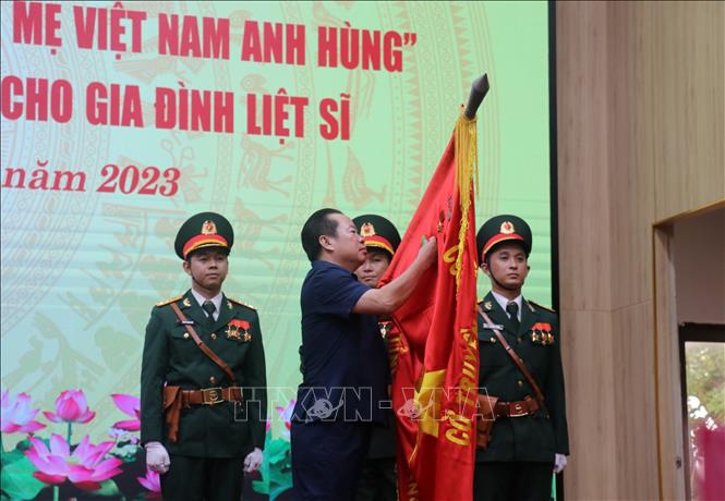 Thừa ủy quyền của Chủ tịch nước, Phó Bí thư Thường trực Tỉnh ủy Kiên Giang Mai Văn Huỳnh gắn Huân chương bảo vệ Tổ quốc hạng Ba lên cờ truyền thống. Ảnh: Lê Huy Hải - TTXVN
 