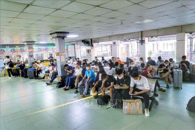Người dân ngồi chờ xe để về quê hoặc đi du lịch dịp nghỉ lễ 2/9 tại bến xe Nước Ngầm. Ảnh: Tuấn Đức - TTXVN