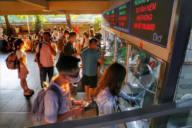 Người dân xếp hàng mua vé tại bến xe Nước Ngầm. Ảnh: Tuấn Đức - TTXVN