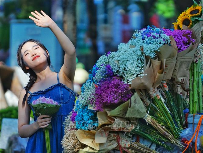 Trào lưu check-in bên xe hoa rong thu hút chủ yếu là các bạn nữ. Ảnh: Khánh Hoà - TTXVN