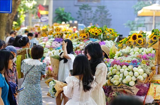 Rất đông các bạn trẻ thích thú check-in, chụp ảnh với những chiếc xe hoa trong tiết trời Thu Hà Nội. Ảnh: Khánh Hoà - TTXVN