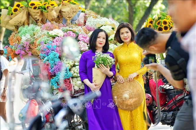 Trào lưu này không chỉ thu hút các bạn trẻ, mà các chị, các cô cũng thướt tha những bộ váy áo đẹp nhất để chụp ảnh cùng những chiếc xe hoa rong. Ảnh: Khánh Hoà - TTXVN