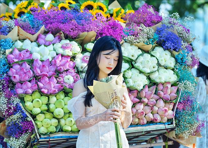 Cầm bó hoa bên xe hoa rong dường như ai cũng cảm thấy mình đẹp và dịu dàng hơn. Ảnh: Khánh Hoà - TTXVN