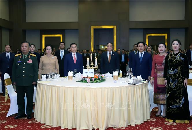 Đại sứ Việt Nam tại Lào Nguyễn Bá Hùng cùng các quan khách Lào tiến hành nghi lễ chào cờ. Ảnh: Phạm Kiên - Phóng viên TTXVN tại Lào