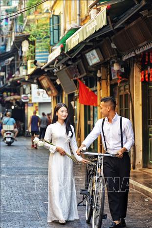 Một cặp đôi trên phố Tạ Hiện, quận Hoàn Kiếm trong sáng mùng 2 tháng 9. Ảnh: Khánh Hoà - TTXVN